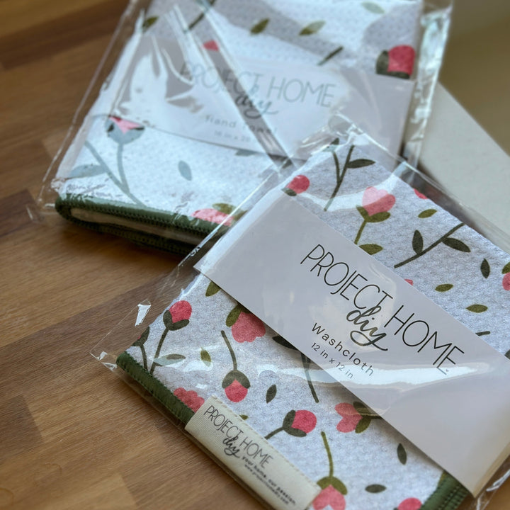 Packaged washcloths with floral design on a wooden surface